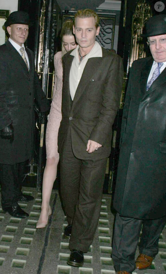 L'acteur américain Johnny Depp, teint en blond, et sa compagne Amber Heard sortant du restaurant Ronnie Scott à Londres, le 25 octobre 2013