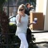 Charlize Theron, ultrachic en sweater et jean blanc, sac Bottega Veneta et bottines Salvatore Ferragamo, se promène avec sa mère Gerda à West Hollywood. Le 10 janvier 2014.
