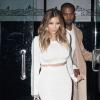 Kim Kardashian quitte le restaurant Mr Chow avec son fiancé Kanye West, habillée d'un ensemble crop top et jupe moulante blanc Calvin Klein, d'un sac Hermès et de sandales Giuseppe Zanotti. Beverly Hills, le 12 janvier 2014.