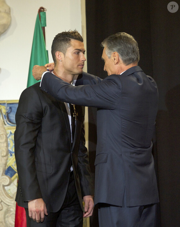 Le footballeur Cristiano Ronaldo est decoré par le président portugais Anibal Cavaco Silva de la médaille du grand officier de l'Ordre de l'Infant Dom Henri lors d'une cérémonie au palais présidentiel de Belem à Lisbonne le 20 janvier 2014.