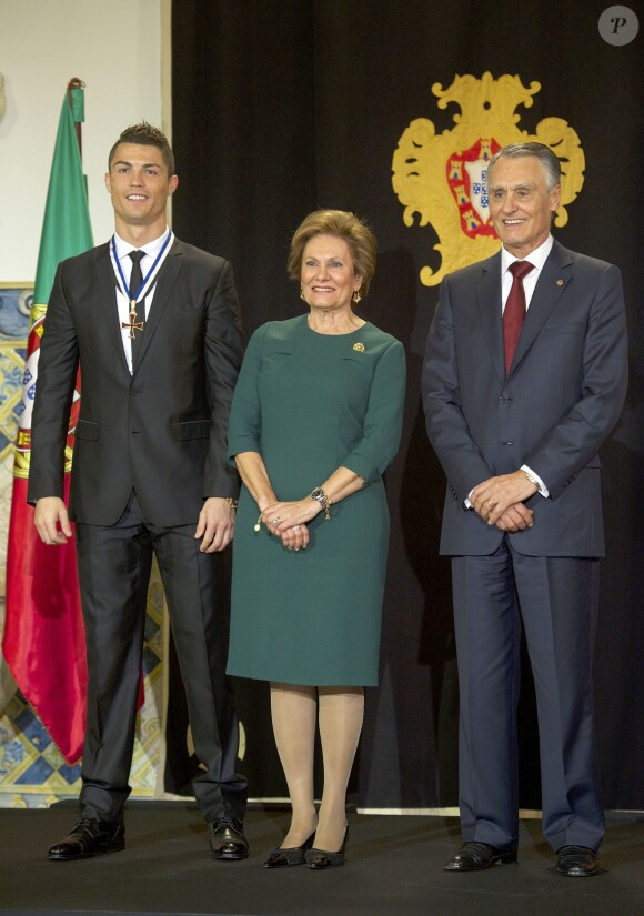 Cristiano Ronaldo est decoré de la médaille du grand officier de l'Ordre de l'Infant Dom Henri par le président portugais Anibal Cavaco Silva, accompagné de sa femme, lors d'une cérémonie au palais présidentiel de Belem à Lisbonne le 20 janvier 2014.