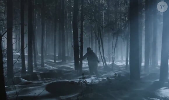 Zlatan se promène dans les sous bois la nuit tombée, avec un fusil, pour Volvo, janvier 2014.