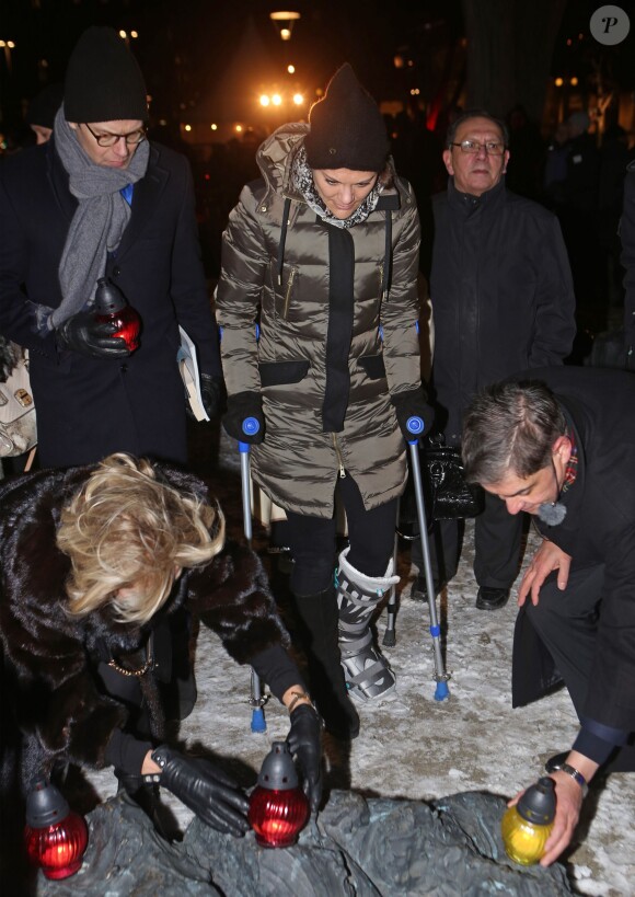 La princesse Victoria de Suède, toujours aidée de béquilles en raison d'une entorse, et son mari le prince Daniel prenaient part le 27 janvier 2014 aux commémorations annuelles de l'Holocauste, place Raoul Wallenberg à Stockholm.