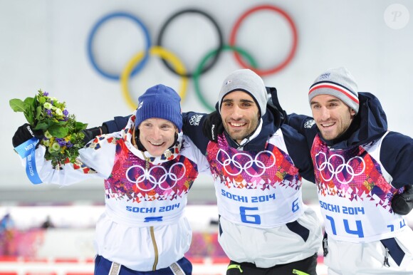 Martin Fourcade sur la plus haute marche du podium accompagné de Ondrej Moravec et Jean-Guillaume Béatrix au Laura Cross-Country and Biathlon Centre à Krasnaya Polyana, le 10 février 2014 lors des Jeux olympiques de Sotchi, le 10 février 2014, après sa victoire en poursuite