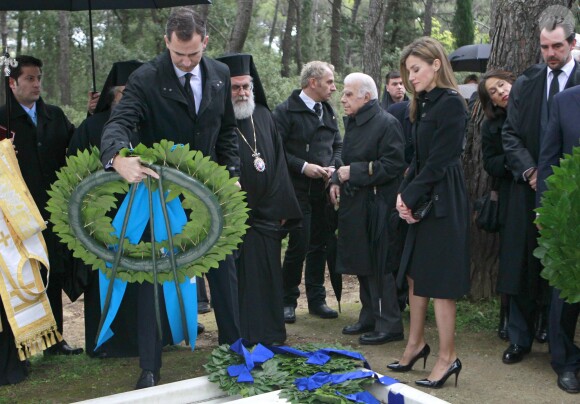 Le prince Felipe déposant une couronne sous le regard de la princesse Letizia d'Espagne et du prince Nikolaos de Grèce lors de la cérémonie organisée à la nécropole royale du domaine Tatoï, au nord d'Athènes, le 6 mars 2014 pour commémorer les 50 ans de la mort du roi Paul Ier de Grèce.