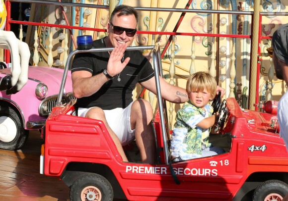 Elton John et son mari David Furnish s'amusent sur un manège avec leurs deux fils Elijah Joseph Daniel Furnish John et Zachary Jackson Levon Furnish, pendant leurs vacances en famille à Saint-Tropez. Le 22 août 2013.