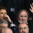 Gérard Depardieu et une amie assistent au match entre le PSG et Chelsea au Parc des Princes à Paris le 2 avril 2014.