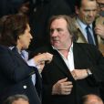 Gérard Depardieu et une amie assistent au match entre le PSG et Chelsea au Parc des Princes à Paris le 2 avril 2014.