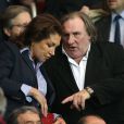Gérard Depardieu et une amie assistent au match entre le PSG et Chelsea au Parc des Princes à Paris le 2 avril 2014.