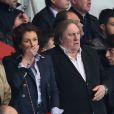 Gérard Depardieu et une amie assistent au match entre le PSG et Chelsea au Parc des Princes à Paris le 2 avril 2014.