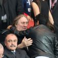 Gérard Depardieu et Jamel Debbouze se saluent amicalement pendant le match de Ligue des Champions entre le PSG et Chelsea au Parc des Princes à Paris le 2 avril 2014.