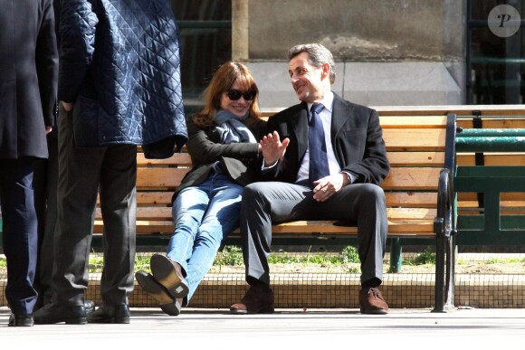 Nicolas Sarkozy et sa femme Carla Bruni se prélassent sur un banc du lycée de leur bureau de vote dans le 16e arrondissement à Paris, le 23 mars 2014.