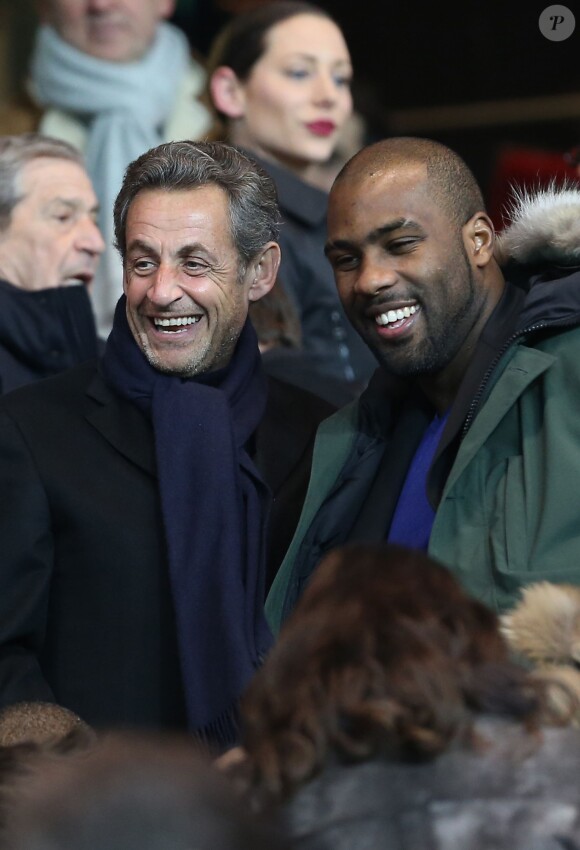 Nicolas Sarkozy et Teddy Riner lors du match du championnat de France de football entre le PSG et Marseille au Parc des Princes à Paris le 2 mars 2014