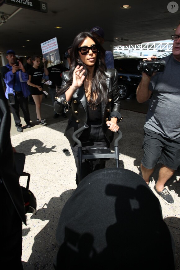 Kim Kardashian et sa fille North quittent l'aéroport de LAX à destination de Paris, le 17 mai 2014.