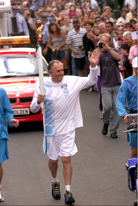 Sir Jack Brabham porte la flamme olympique dans les rues de Byron Bay, le 25 août 2000