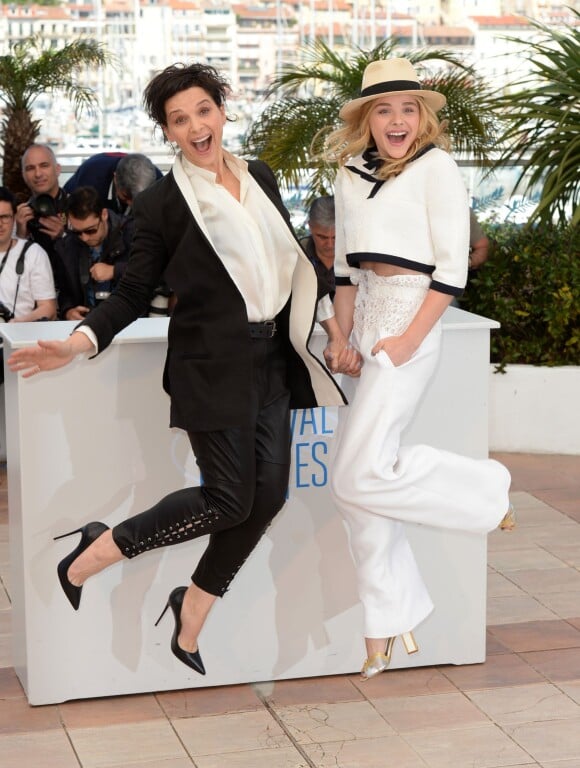 Festival de Cannes 2014 : Juliette Binoche montre à sa jeune partenaire dans Sils Maria, Chloë Grace Moretz, comment on peut s'amuser lors d'un photocall. Son énergie est contagieuse !