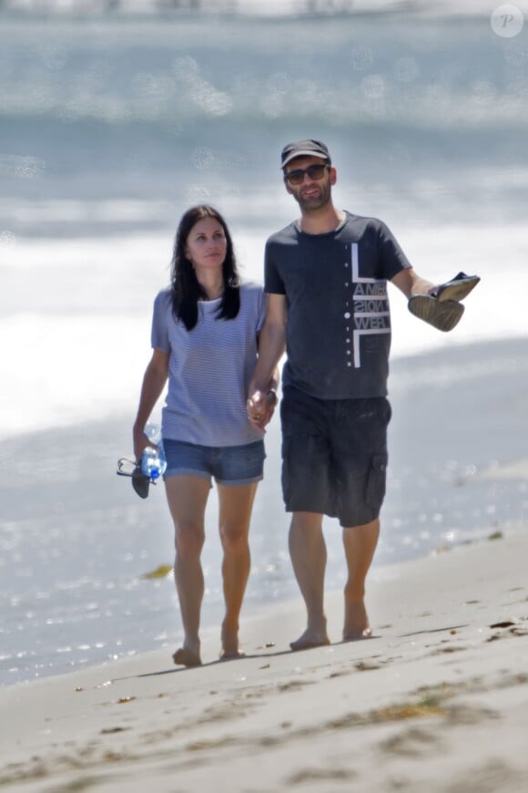 Exclusif - L'actrice Courtney Cox et son petit-ami Johnny McDaid lors d'une balade romantique main dans la main sur la plage à Malibu, le 30 mai 2014.