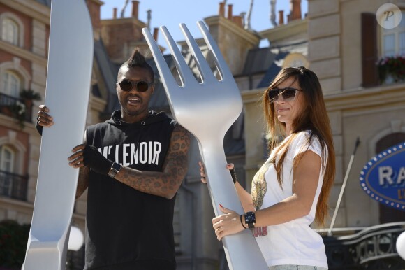 Djibril Cissé et sa compagne assistent en avant-première à l'inauguration de la nouvelle attraction Ratatouille, à Disneyland Paris, à Marne-la-Vallée, le 21 juin 2014.