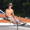 Justin Bieber se relaxe sur un yacht avec des amis à Miami, le 3 juillet 2014. Le jeune chanteur boit une bière assis sur l'avant du bateau.