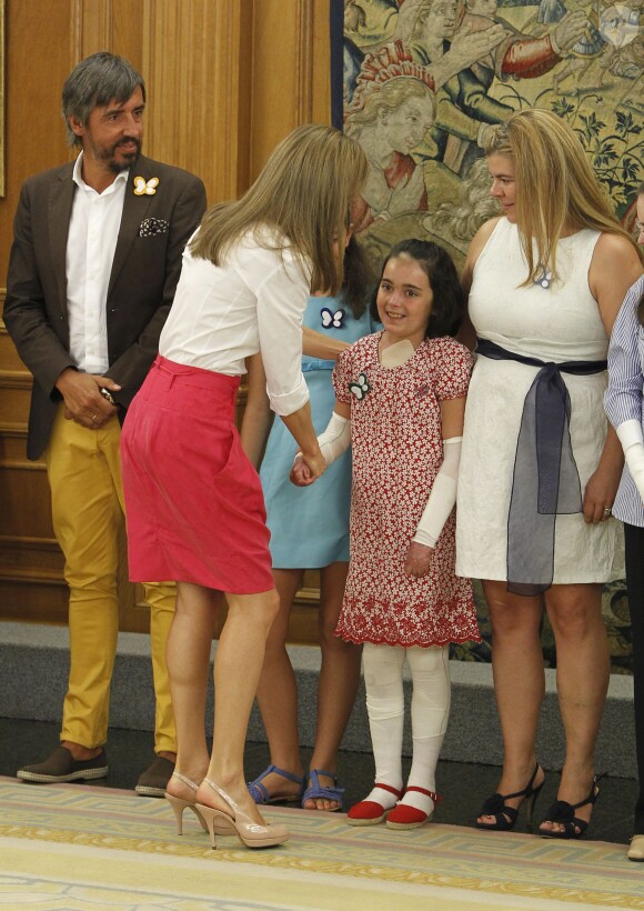 La reine Letizia d'Espagne accueille une fillette malade en audience avec une délégation de l'association Debra España au palais de la Zarzuela à Madrid le 28 juillet 2014.