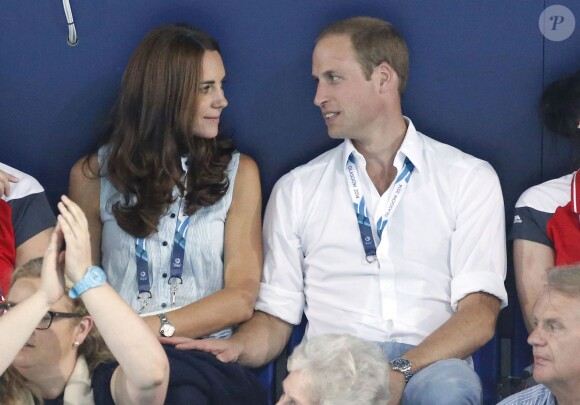 Petit moment de tendresse entre Kate Middleton et le prince William dans les gradins du Tolcross Swimming Centre de Glasgow le 28 juillet 2014 pour les épreuves de natation des XXe Jeux du Commonwealth.