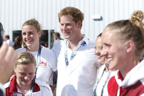 Le prince Harry avec des hockeyeuses aux XXe Jeux du Commonwealth, le 28 juillet 2014 à Glasgow.