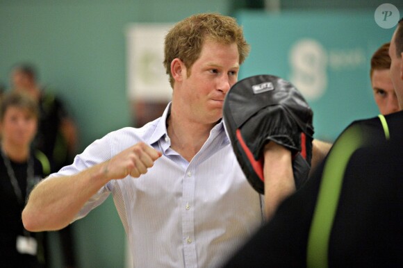 Le prince Harry s'initie à la boxe lors d'une visite avec son frère William à des protagonistes du programme Coach Core en marge des XXe Jeux du Commonwealth, le 29 juillet 2014 à Glasgow.