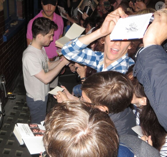 Daniel Radcliffe signe des autographes a sa sortie du theatre Coward à Londres le 14 août 2013