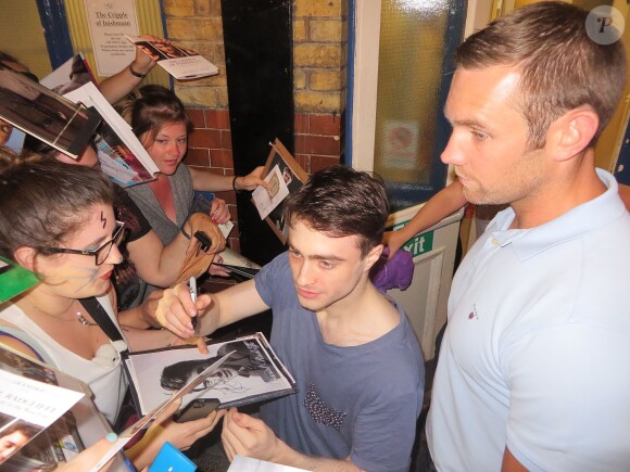 Daniel Radcliffe signe des autographes a ses fans a la sortie du théâtre "Duke Of York" à Londres, le 20 août 2013