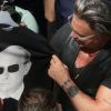 Mickey Rourke essaie des tee-shirts avec le portrait de Vladimir Poutine dans le magasin GUM à Moscou, le 11 août 2014.