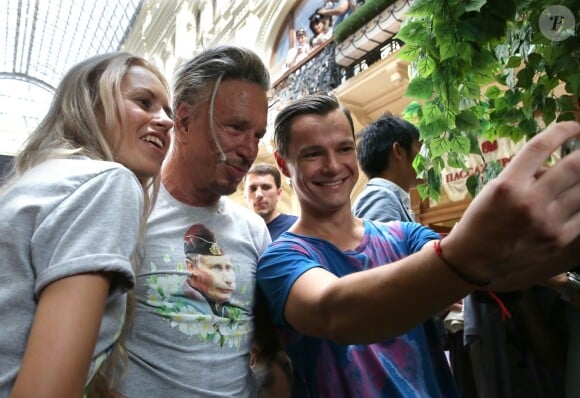 Mickey Rourke essaie des tee-shirts avec le portrait de Vladimir Poutine dans le magasin GUM à Moscou, le 11 août 2014.