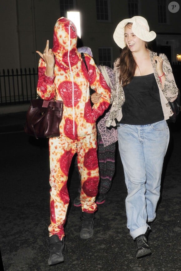 Cara Delevingne, en combinaison à l'imprimé de pizza, rentre à Londres apès un week-end à Ibiza. Le 14 août 2014.