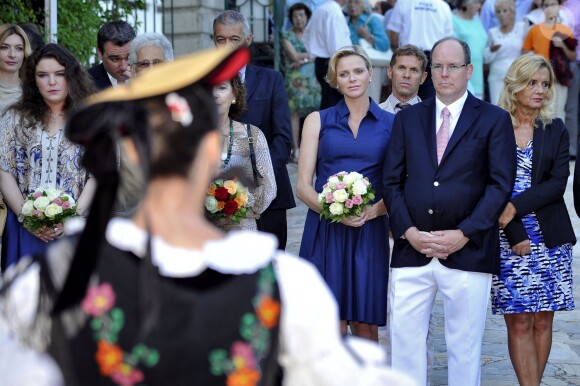 La princesse Charlene de Monaco, enceinte de six mois, et le prince Albert II de Monaco ont été accueillis par un groupe de danseuses folkloriques le 1er septembre 2014 lors de leur participation au traditionnel pique-nique des Monégasques, organisé au parc Princesse-Antoinette par la mairie.