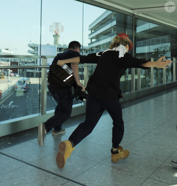 Cara Delevingne plaisante avec les photographes à son arrivée à l'aéroport de Heathrow à Londres, le 2 septembre 2014.
