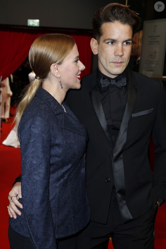 Scarlett Johansson (César d'honneur) (habillée avec une veste " Bar " en dentelle bleu marine, pantalon en crêpe de soie bleu marine et une pochette Dior) et son fiancé Romain Dauriac à Paris, le 28 février 2014.