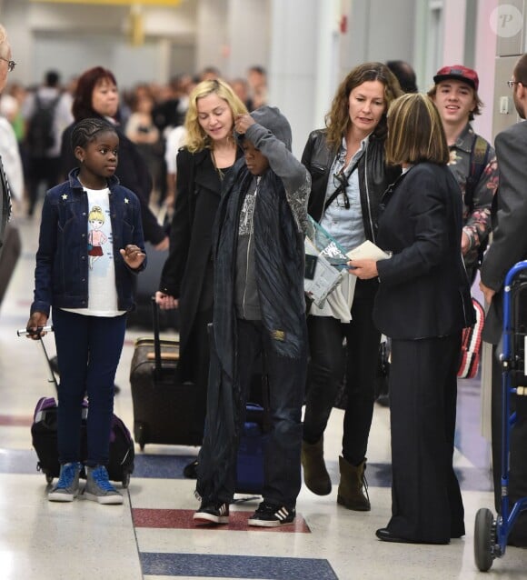 Madonna avec ses enfants Rocco, David et Mercy à leur retour de vacances à l'aéroport JFK de New York le 27 août 2014