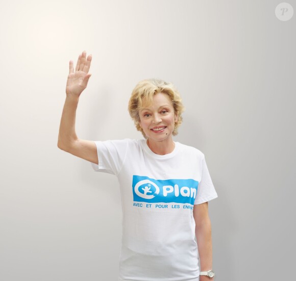 Caroline Sihol prend la pose et lève la main pour l'ONG Plan International dans le cadre de la campagne "50 000 mains levées pour l'éducation des filles"