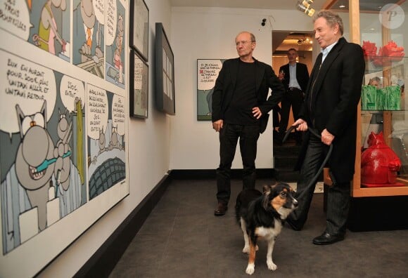 Philippe Geluck, Michel Drucker et sa chienne Isia - Vernissage de l'exposition "Tout L'Art Du Chat" de Philippe Geluck à la galerie Huberty-Breyne à Paris, le 14 octobre 2014.