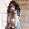 Milla Jovovich enceinte, son mari Paul W. S. Anderson et leur fille Ever Gabo s'amusent à Disneyland à Anaheim en Californie le 23 octobre 2014. 