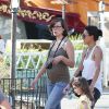 Milla Jovovich enceinte, son mari Paul W. S. Anderson et leur fille Ever Gabo s'amusent à Disneyland à Anaheim en Californie le 23 octobre 2014. 