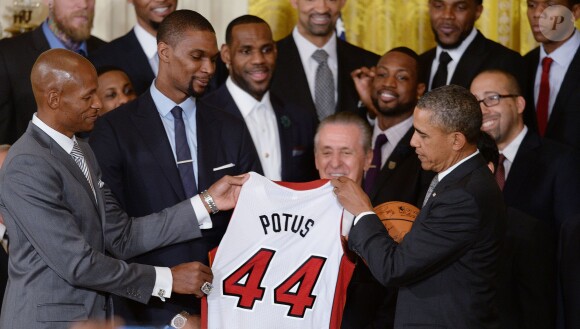 Barack Obama a reçu un maillot floqué POTUS (President Of The United States) des mains de Chris Bosh et Ray Allen, alors qu'il recevait l'équipe championne NBA du Heat de Miami à la Maison Blanche à Washington, le 14 janvier 2014