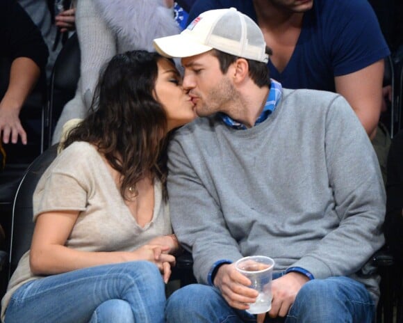 Mila Kunis et son fiancé Ashton Kutcher s'embrassent tendrement pendant le match de basket des Lakers face à Oklahoma City, le 19 décembre 2014.