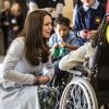 Kate Catherine Middleton, duchesse de Cambridge, enceinte discute avec Martina McDonagh, 17 ans, qui est en chaise roulante lors de l'inauguration du Kensington Leisure Centre à Londres le 19 janvier 2015. Elle porte un manteau de la marque Séraphine.  The Duchess of Cambridge talks to Martina McDonagh aged 17 as she sits in her wheelchair. The Duchess is touching he stomach and describing how she can feel her baby kick. The Duchess was formally opening new Kensington leisure centre in London on January 19, 2015. The Duchess of Cambridge formally opened the Kensington Leisure Centre by touring ethe facilities, including the swimming pool, gym and sauna and watchd groups of children from nearby Primary Schools in the Main Sports Hall playing various sports.19/01/2015 - Londres