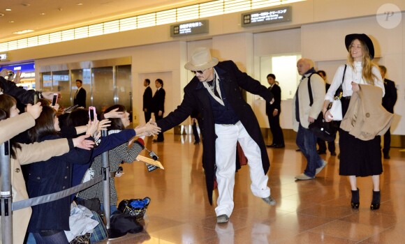Johnny Depp, qui salue ses fans, et sa fiancée Amber Heard, à l'aéroport de Tokyo, le 26 janvier 2015.