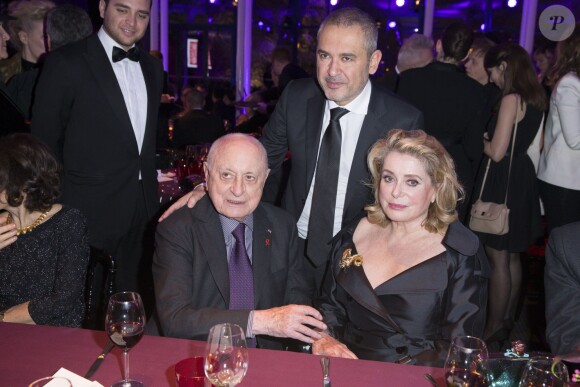 Elie Saab, Pierre Bergé et Catherine Deneuve au Dîner de la mode pour le Sidaction au pavillon d'Armenonville à Paris le 29 janvier 2015. 