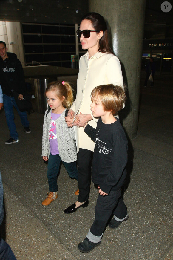 Angelina Jolie et ses jumeaux, Knox et Vivienne (5 ans), à l'aéroport de Los Angeles, le 11 février 2015. Le trio revient d'un voyage rapide à Londres où la star a recontré le secrétaire d'Etat William Hague. 