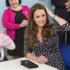 Kate Middleton, duchesse de Cambridge, enceinte et portant une robe Asos lors d'une visite dans un foyer pour enfants à Londres le 18 mars 2015