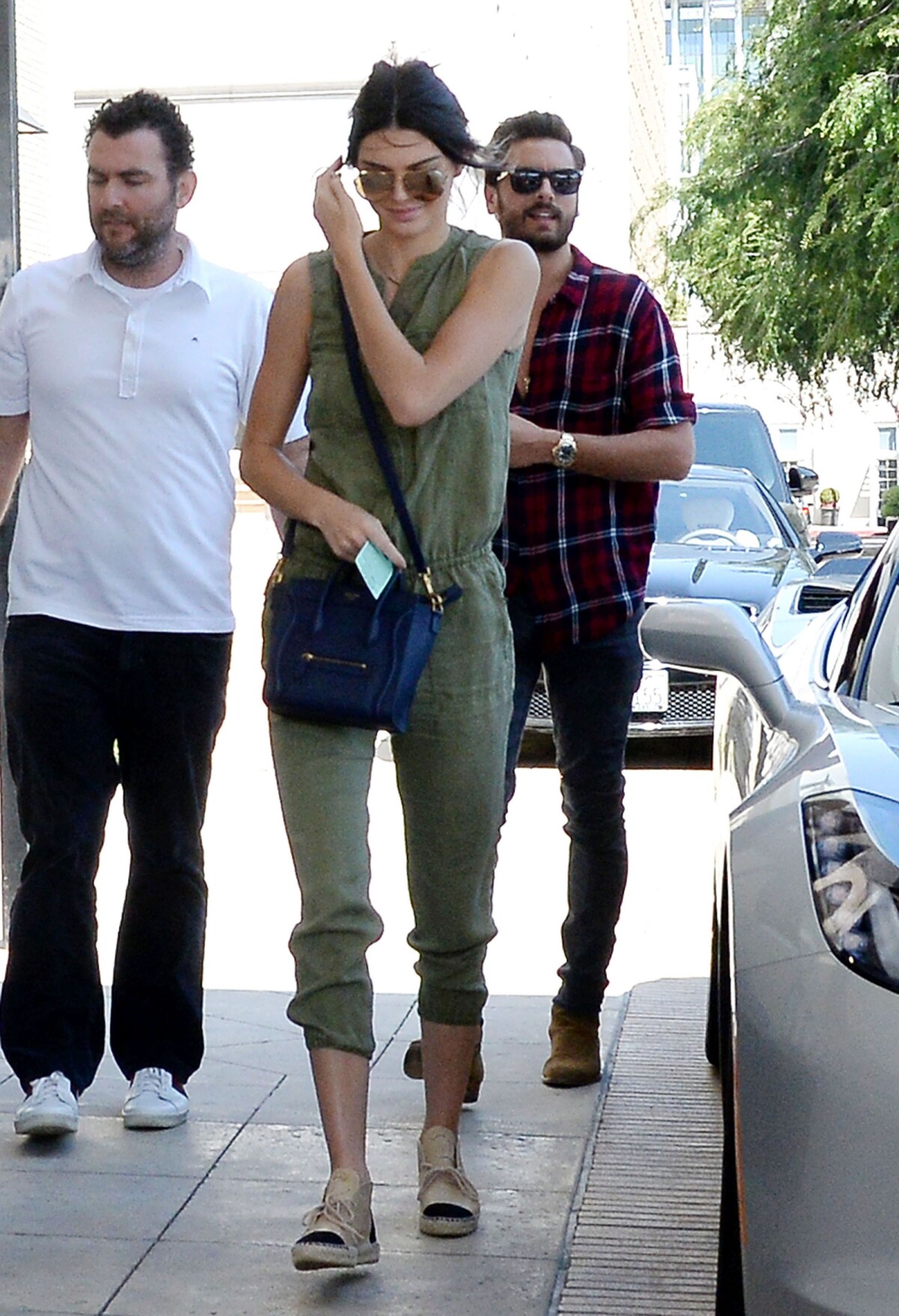 Photo Kendall Jenner arrive au centre commercial Barneys New York avec Scott Disick habillee d une combinaison kaki Joie. Des lunettes Linda Farrow modele 307 un sac Celine et des espadrilles Chanel c...
