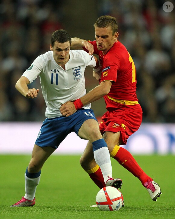 L'international anglais Adam Johnson à la lutte avec le Monténégrin Milorad Pekovic lors d'un match de qualification pour l'Euro 2012 en octobre 2010 à Wembley, Londres.