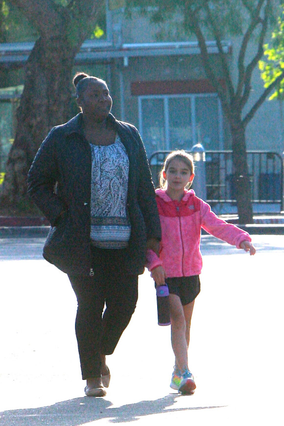 Suri Cruise avec sa nounou pour aller faire de l'athlétisme à Los Angeles, le 8 avril 2015. À 9 ans, la fille de Katie Holmes et Tom Cruise est très sportive.